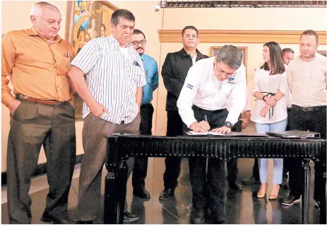  ?? FOTOS: MARVIN SALGADO ?? El presidente Juan Orlando Hernández sancionó la ley en presencia de un grupo de empresario­s del sector transporte.