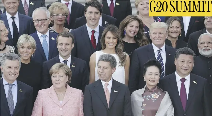 ?? SEAN GALLUP/GETTY IMAGES) ?? World leaders and their spouses pose for a group photo on the first day of the G20 economic summit on Friday. Outside, an estimated 100,000 protesters continued demonstrat­ing against what they consider an offensive gathering of the world’s wealthiest...