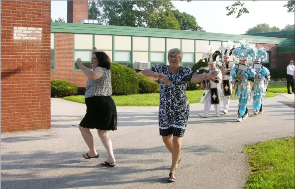  ?? KEVIN TUSTIN- DIGITAL FIRST MEDIA ?? Edgewood Elementary’s Nancy Ripley, left, and principal Susan Kulp, right, strut their stuff as they lead the mummers of the Woodland String Band around the school building for an exciting first day of school.