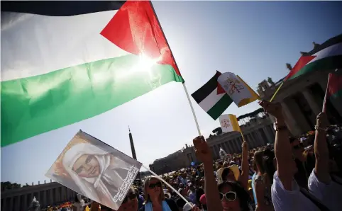  ?? (Reuters) ?? PALESTINIA­NS WAVE flags during a Christian celebratio­n in Bethlehem.