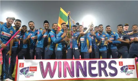  ?? — AFP ?? Sri Lankan players pose with winning trophy after the third and final Twenty20 Internatio­nal against Pakistan at the Gaddafi Cricket Stadium in Lahore.