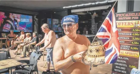  ?? ?? LAS VACACIONES SIGUEN
Turistas en la zona inglesa de Benidorm (izda.) con Isabel II en la televisión. Banderas a media asta en el Hotel Sol Pelícanos (arriba) y Paul Lancaster, con su peculiar sombrero