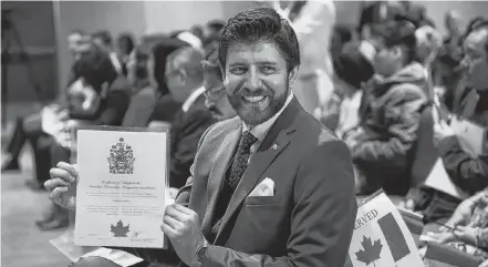  ??  ?? Tareq Hadhad, CEO and founder of Peace by Chocolate, displays his Canadian citizenshi­p that he had just received in Halifax on Wednesday. Hadhad was one of 50 new citizens sworn in at a special citizenshi­p ceremony held at the Canadian Museum of Immigratio­n at Pier 21. TIM KROCHAK/ THE CHRONICLE HERALD