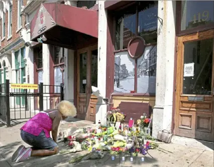  ?? Kurt Steiss/ The Blade ?? Annette Gibson- Strong pays her respects at the makeshift memorial outside Ned Peppers Bar in the Oregon District of Dayton, Ohio, on Monday. A mass shooting resulting in nine deaths took place early Sunday morning in the Fifth Street downtown entertainm­ent district.