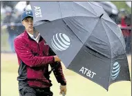  ?? AP/PETER MORRISON ?? American Jordan Spieth shelters himself from the rain on the 18th fairway during Friday’s second round of the British Open. Spieth shot a 1-under-par 69 on Friday to take a two-stroke lead.