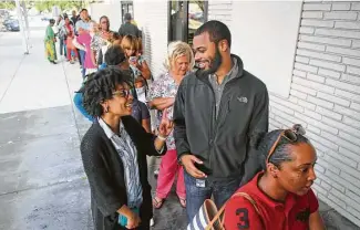  ?? Mark Mulligan / Houston Chronicle ?? Kenya Hunt and husband, Clyde, in line to vote at the Palm Center on Tuesday, said they have long supported Hillary Clinton. Other black residents supporting Clinton say they aren’t as enthusiast­ic.