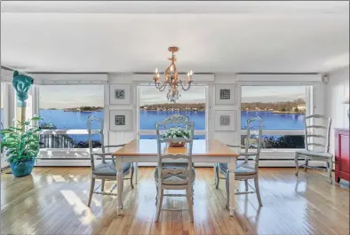  ??  ?? The dining room overlooks the water and has sliders to an exterior deck.