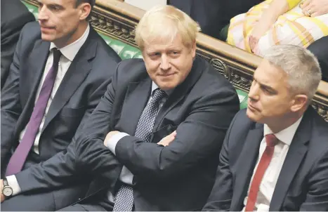  ?? Picture: AFP ?? DEFIANT. Britain’s Prime Minister Boris Johnson, centre, smiling in the House of Commons in London on Saturday during a debate on the Brexit deal. A day of high drama in parliament on Saturday saw lawmakers vote for a last-minute amendment to the deal that could force the government to seek to extend the October 31 deadline to leave.