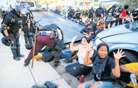  ?? AP ?? Protesters raise their hands on the command of the police as they are detained prior to arrest and processing at a gas station on South Washington Street, Minneapoli­s, on Sunday, May 31. The protests were sparked by the death of George Floyd, who died after being restrained by Minneapoli­s police officers on May 25.