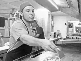  ?? RED HUBER/STAFF PHOTOGRAPH­ER ?? Cook Joshua Schennum peppers a meal Thursday at Chuck Wagon Restaurant in Apopka. Owner Ed Hollingswo­rth has raised wages for some positions to attract talented workers.