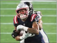  ?? Charles Krupa / Associated Press ?? Baltimore Ravens cornerback Marcus Peters, rear, tackles New England Patriots wide receiver Jakobi Meyers after a pass reception in the second half on Sunday.