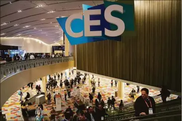  ?? Associated Press photos ?? People walk through the Venetian Expo center during the CES tech show Thursday in Las Vegas.