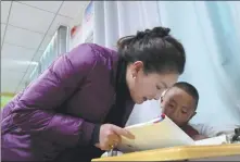  ?? ?? Left: A Tibetan teacher instructs a student at a primary school in Sernyi district of Nagchu, Xizang autonomous region, in October.