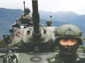  ?? TYRONE SIU / REUTERS FILES ?? A Taiwanese soldier stands in front of a M60A3 battle tank during a military drill in Hualien, Taiwan, in 2018.