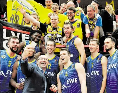  ?? BILD: IMAGO ?? Selfie mit den Fans: Trainer Mladen Drijencic (Mitte) hält das Smartphone und schießt ein Gruppenbil­d mit Mannschaft und Anhängern.