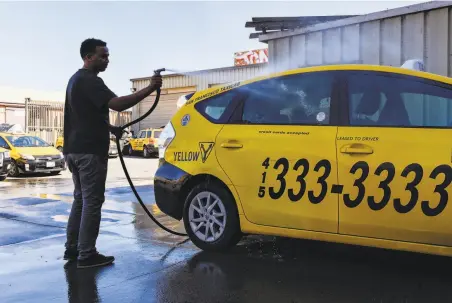  ?? Kate Munsch / Special to The Chronicle ?? Ayenom Gebremedhi­n washes a taxi in the mechanic shop at Yellow Cab headquarte­rs in San Francisco. The company’s CEO says reclassify­ing drivers as employees would drive up costs dramatical­ly.