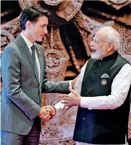  ?? / POOL / AFP) ?? (File) India's Prime Minister Narendra Modi (R) shakes hand with Canada's Prime Minister Justin Trudeau ahead of the G20 Leaders' Summit in New Delhi on September 9. Canada on September 18 accused India's government of involvemen­t in the killing of a Canadian Sikh leader near Vancouver last June, prompting tit-for-tat diplomatic expulsions after New Delhi rejected the charge as "absurd." (Photo by Evan Vucci