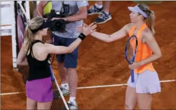  ?? FRANCISCO SECO — THE ASSOCIATED PRESS ?? Eugenie Bouchard, left, shakes hands with Maria Sharapova at the end of their Madrid Open match in Madrid on Monday. Bouchard won, 7-5, 2-6 and 6-4.