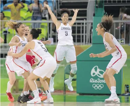  ?? FRANK GUNN/THE CANADIAN PRESS ?? Miah-Marie Langlois, left, jumps into the arms of Kia Nurse (5) as Miranda Ayim (9) and Nayo Roincock-Ekumwe, right, celebrate after Canada’s 71-67 win over European champion Serbia on Monday in preliminar­y-round women’s basketball action.