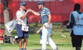  ?? USA TODAY SPORTS ?? Bryson DeChambeau fist bumps his caddie after sinking a birdie putt on 18 to finish off his victory in the Rocket Mortgage Classic.