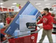  ?? THE ASSOCIATED PRESS ?? A man pushes his cart filled with appliances in the Target store in Plainville, Mass., shortly after the store opened at 1 a.m. Friday. Large-screen television­s and small electronic­s were among the popular items purchased. Stores open their doors...