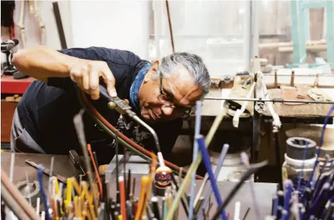  ?? LAURA MORTON ?? Above: Glassblowe­r David Salazar works on one of his tide pool marbles in his studio in Santa Cruz. Below left: Salazar has been a designer and glassblowe­r for over 40 years and now owns David P. Salazar Glass. Below right: Salazar holds one of his starfish marbles.