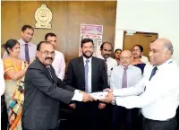  ??  ?? Registrar General of Companies D.N.R. Siriwarden­a (left) and Partner of KPMG Sri Lanka C.P. Jayatilake (right) exchanging the EROC MOU in the presence of the Minister Rishad Bathiudeen (centre)