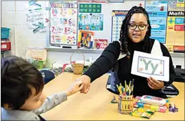  ?? JULIA NIKHINSON / AP ?? Student teacher Lana Scott, who plans to graduate from Bowie State University in the spring of 2023, teaches a small group of kindergart­ners at Whitehall Elementary School the alphabet on Jan. 24 in Bowie, Md.