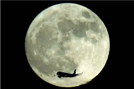  ?? (foto Reuters) ?? Vicinissim­a Un’immagine scattata dall’aeroporto di Heathrow, a Londra: la super Luna è stata visibile nella notte appena trascorsa