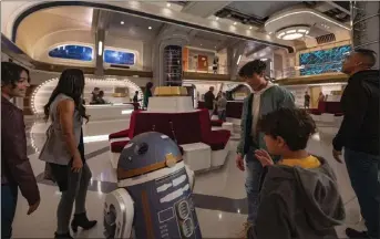  ?? PHOTOS BY MATT STROSHANE ?? People take in the atmosphere at the Star Wars: Galactic Starcruise­r hotel at Disney's Hollywood Studios in Florida, where the design suggests a spaceship and guests are invited to role-play in scenarios from the movies' universe.