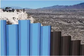  ?? CHRISTIAN TORRES/ASSOCIATED PRESS ?? A border patrol agent watches the Mexico-U.S. border fence on the Mexican side, separating the towns of Anapra, Mexico, and Sunland Park, New Mexico, on Wednesday.