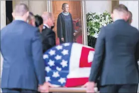  ?? ANDREW HARNIK — THE ASSOCIATED PRESS ?? The flag-draped casket of Justice Ruth Bader Ginsburg, carried by Supreme Court police officers, arrives in the Great Hall at the Supreme Court in Washington on Wednesday.