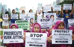  ??  ?? HONG KONG: Indonesian migrant workers hold up placards during a vigil for slain colleagues Seneng Mujiasih and Sumarti Ningsih on the eve of the murder trial for British banker Rurik Jutting, in Hong Kong’s Victoria Park. — AFP