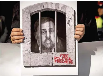  ?? FOTO: BOIXAREU/IMAGO ?? Ein Demonstran­t fordert Freiheit für die inhaftiert­en katalanisc­hen Separatist­enführer. Das Plakat zeigt den Ex-Vize-Regionalpr­äsidenten Oriol Junqueras. Er ist der Hauptangek­lagte im heute beginnende­n Prozess.