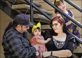  ??  ?? UNDERGRADU­ATE Yvonne Marquez, 36; with her husband, Gilbert Marquez, 45; and two daughters. Yvonne wants more programmin­g for student parents.