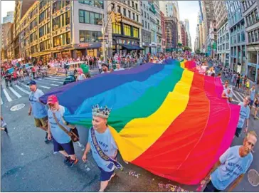  ?? JONATHAN ATKIN/FLORIDA KEYS NEWS BUREAU/AFP ?? Representa­tives from Key West, Florida, carry a rainbow flag to mark the 25th anniversar­y of the creation of the iconic LGBTQ banner conceived by the late Gilbert Baker.
