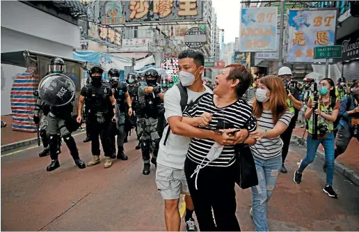  ?? AP ?? A woman argues with police as she was told to stay away from the area in Mongkok, Hong Kong.