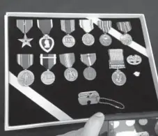  ?? Thomas Watkins, Getty Images ?? Here are the identity tag and medals belonging to Army Master Sgt. Charles Mcdaniel Sr., who was killed in the Korean War in 1950. The tag was given to his family after North Korea handed over the remains of American troops.