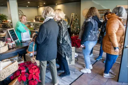  ?? Pittsburgh Post-Gazette ?? Megan McGinnis, owner of The Cheese Queen in Mt. Oliver, welcomes a steady stream of customers during Small Business Saturday. Ms. McGinnis’ store opened in July.