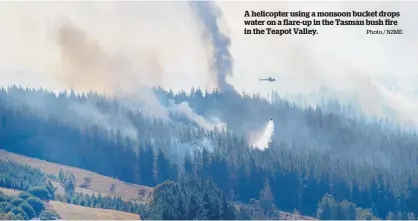  ?? Photo / NZME ?? A helicopter using a monsoon bucket drops water on a flare-up in the Tasman bush fire in the Teapot Valley.