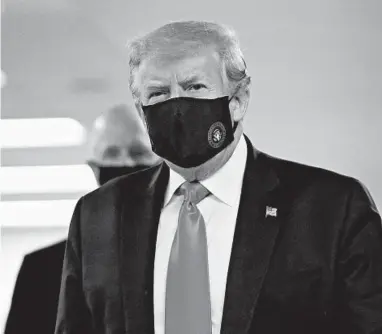  ?? PATRICK SEMANSKY/AP ?? President Donald Trump wears a mask Saturday at Walter Reed National Military Medical Center in Bethesda, Maryland.