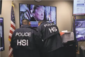  ?? Photos by John Moore / Getty Images ?? ICE agents work in a control room during a crackdown on immigrant gangs in Central Islip, N.Y. Warnings that MS-13 and other gangs pose a dire threat may be overblown, experts say.