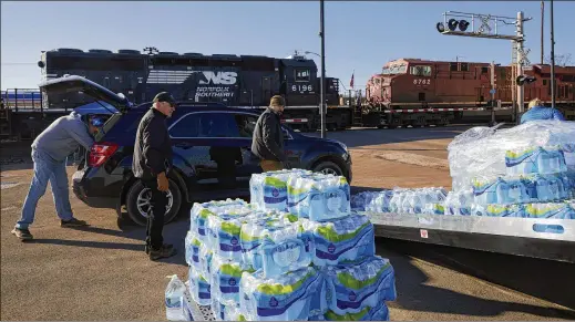  ?? PHOTOS BY BRIAN KAISER/THE NEW YORK TIMES ?? Volunteers distribute free water Feb. 18 to residents after the derailment Feb. 3 of a train carrying toxic chemicals in East Palestine, Ohio. The derailment of a train carrying toxic chemicals upended a region where generation­s of families could afford to buy acres of land, raise livestock and plant gardens.