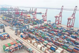  ?? AFP ?? An aerial photo shows cargo containers stacked at a port in Lianyungan­g in China’s eastern Jiangsu province on May 9, 2022.