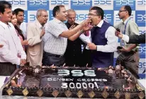  ?? PHOTO: PTI ?? After the Sensex hit the 30,000-mark, a 30-kg cake was cut to celebrate the achievemen­t