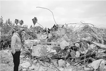  ??  ?? Palestinia­ns check the rubble of a house belonging to the family of a Palestinia­n man suspected of killing an Israeli rabbi last week in the occupied West Bank, after it was demolished overnight. — AFP photo