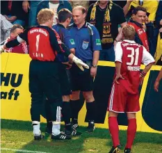  ?? FOTO: DPA ?? Legendär: In Dortmund lieferte sich Linienrich­ter Heiner Müller (rechts) ein Wortgefech­t mit Bayerns Torhüter Oliver Kahn. Schiedsric­hter Markus Merk erkundigte sich danach, was los war.