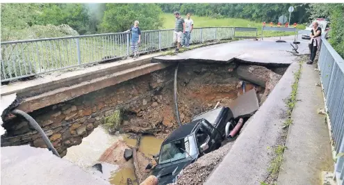  ??  ?? Ein Fahrzeug ist in Kleinblitt­ersdorf im Saarland in ein Loch gestürzt, das der Starkregen in eine Brücke gerissen hat. FOTO: IMAGO