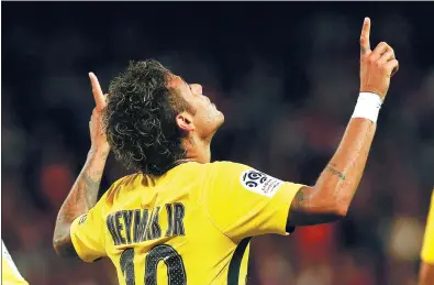  ?? KAMIL ZIHNIOGLU / AP ?? Neymar points skyward after scoring Paris Saint-Germain's third goal against Guingamp in his debut for the club at Stade du Roudourou in northweste­rn France on Sunday evening. PSG won the Ligue 1 match 3-0.