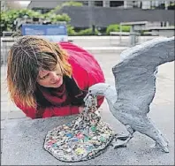  ?? GREENPEACE/SUBMITTED PHOTO ?? A woman takes a close look at “Plasticide,” a sculpture by Jason deCaires Taylor of a seagull vomiting plastic pieces.